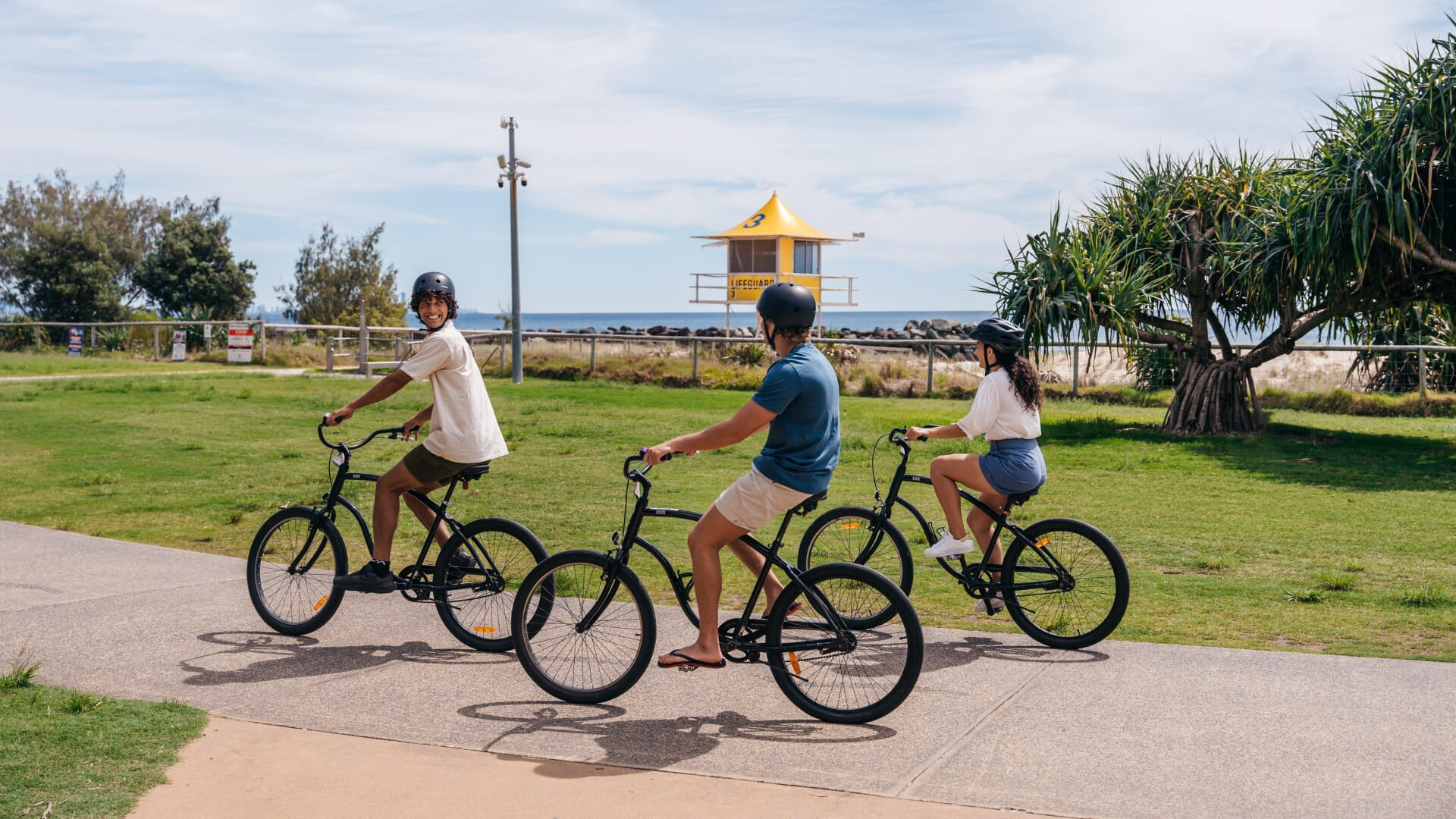 Three teenagers cycling on the beach of Gold Coast