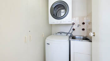 In-apartment laundry with washer, dryer and utility sink at ULTIQA Beach Haven on Broadbeach.