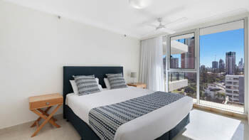Modern white kitchen with stone benchtops and city views at ULTIQA Beach Haven on Broadbeach.