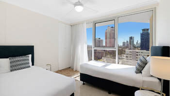 Master bedroom with city skyline views and natural light at ULTIQA Beach Haven on Broadbeach.