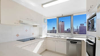 Modern kitchen with stone benchtops and city skyline views at ULTIQA Beach Haven on Broadbeach.