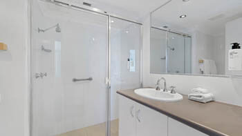 Modern bathroom with glass walk-in shower and vanity at ULTIQA Beach Haven on Broadbeach.