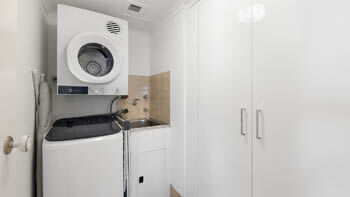In-apartment laundry with washer, dryer and utility sink at ULTIQA Beach Haven on Broadbeach.