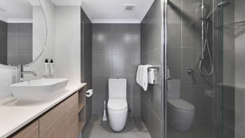 Stylish bathroom with glass shower and contemporary finishes at ULTIQA Beach Haven on Broadbeach.