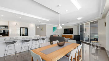 Open plan dining, kitchen and living space in ULTIQA Beach Haven beachfront apartment.