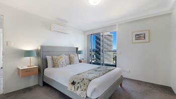 Bright bedroom with high-rise city outlook at ULTIQA Beach Haven on Broadbeach.