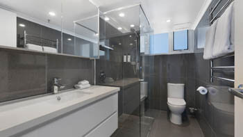 Modern bathroom with walk-in shower at ULTIQA Beach Haven on Broadbeach.