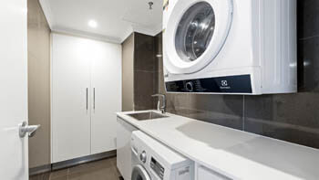 In-apartment laundry with washer, dryer and storage at ULTIQA Beach Haven on Broadbeach.