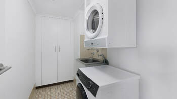 Laundry room with a washing machine, dryer and a lot of storage at ULTIQA Beach Haven on Broadbeach.