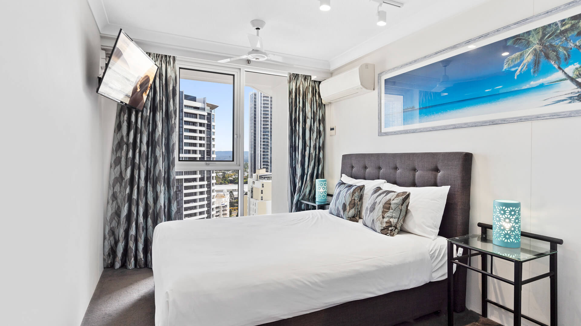 Second bedroom with a king bed and a TV in the corner at ULTIQA Beach Haven on Broadbeach.