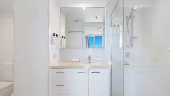 Bright ensuite in the Sub Penthouse at ULTIQA Beach Haven on Broadbeach, featuring a walk-in shower and large mirrored vanity.