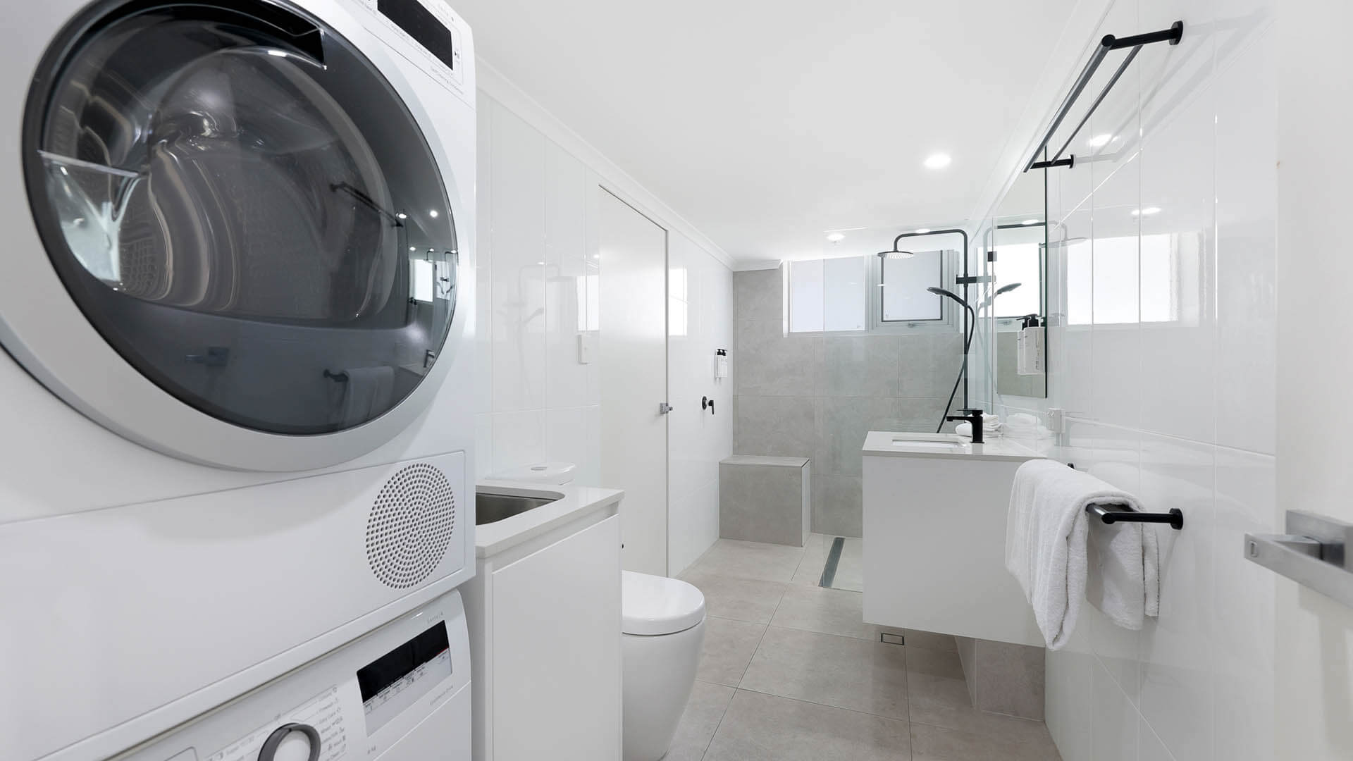 Bathroom featuring a walk-in shower and dual vanity.