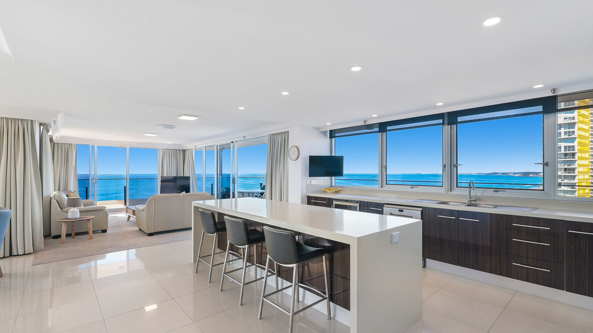 Open-plan kitchen and lounge with ocean views in the Sub Penthouse at ULTIQA Beach Haven on Broadbeach.